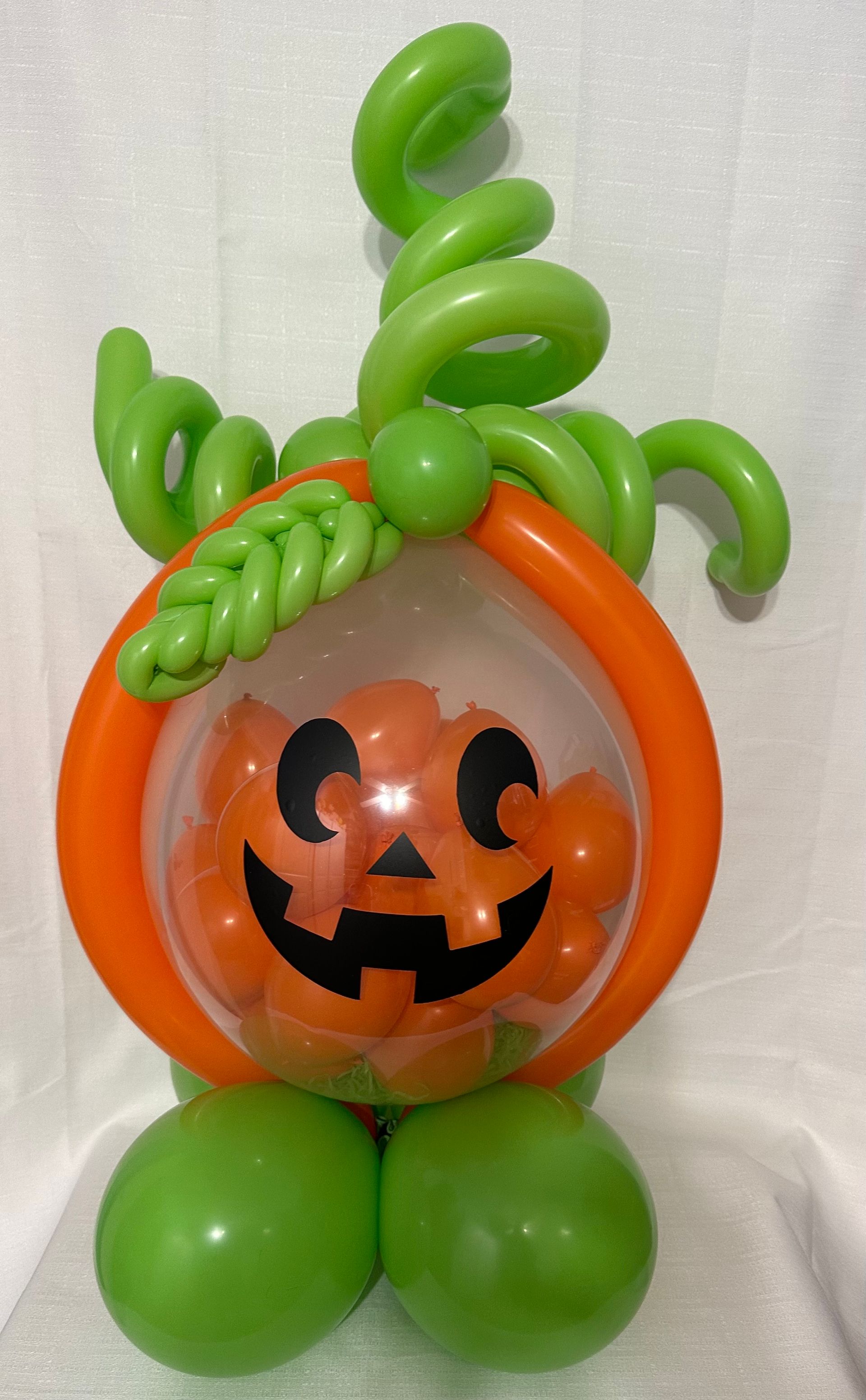 A pumpkin made out of green and orange balloons
