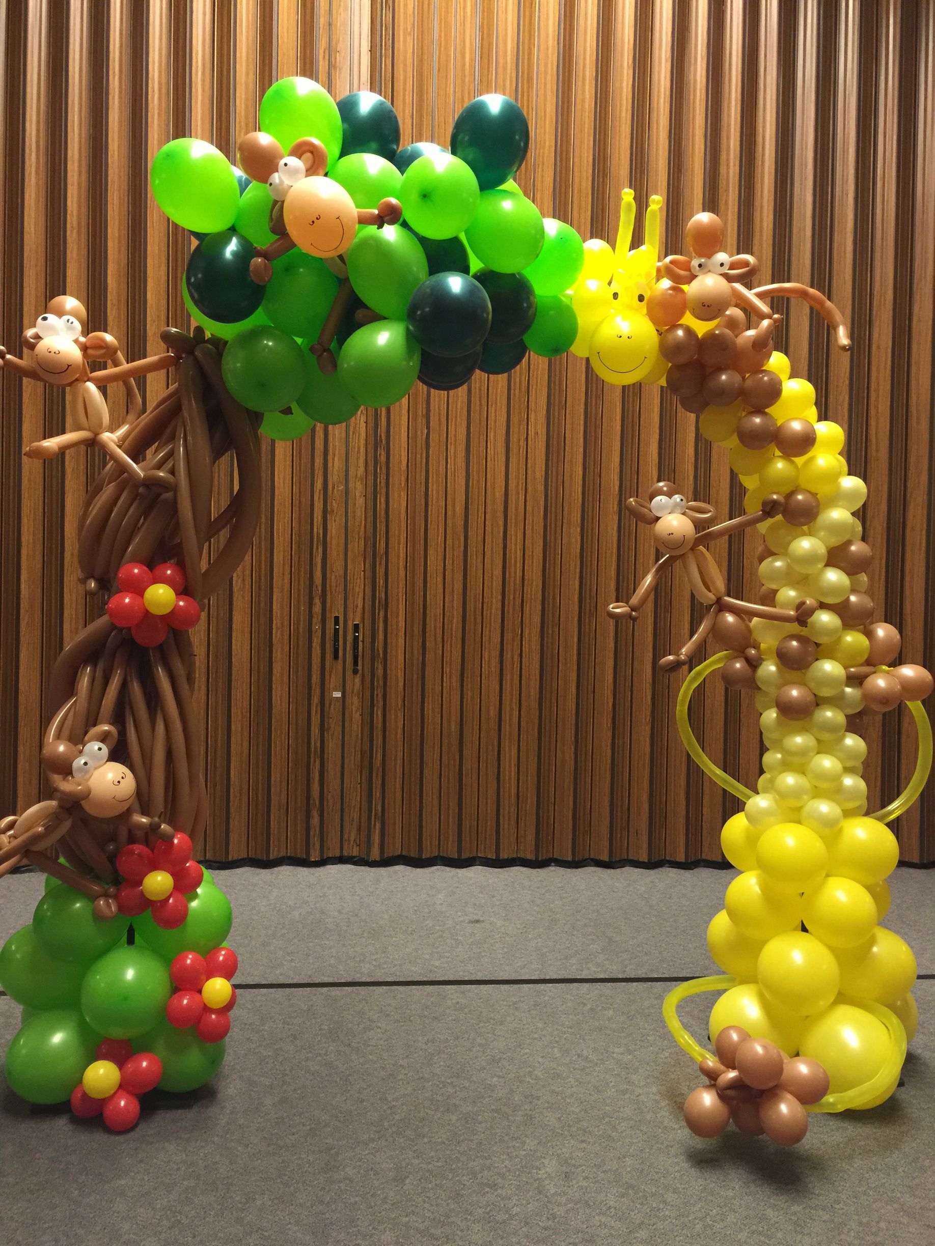 A tree made of balloons with monkeys hanging from it