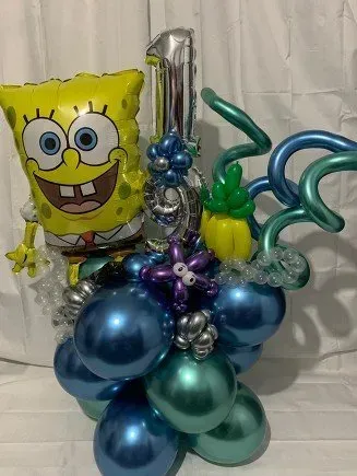 A spongebob balloon is sitting on top of a bunch of balloons.