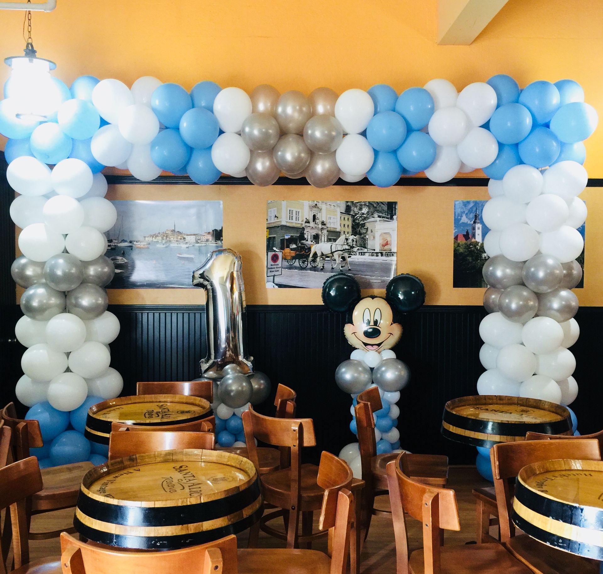 A room decorated with balloons and a mickey mouse balloon