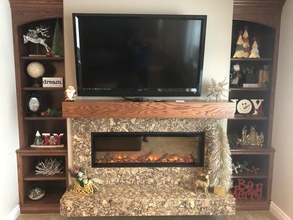 medium dark wood fireplace mantel and side cabinets