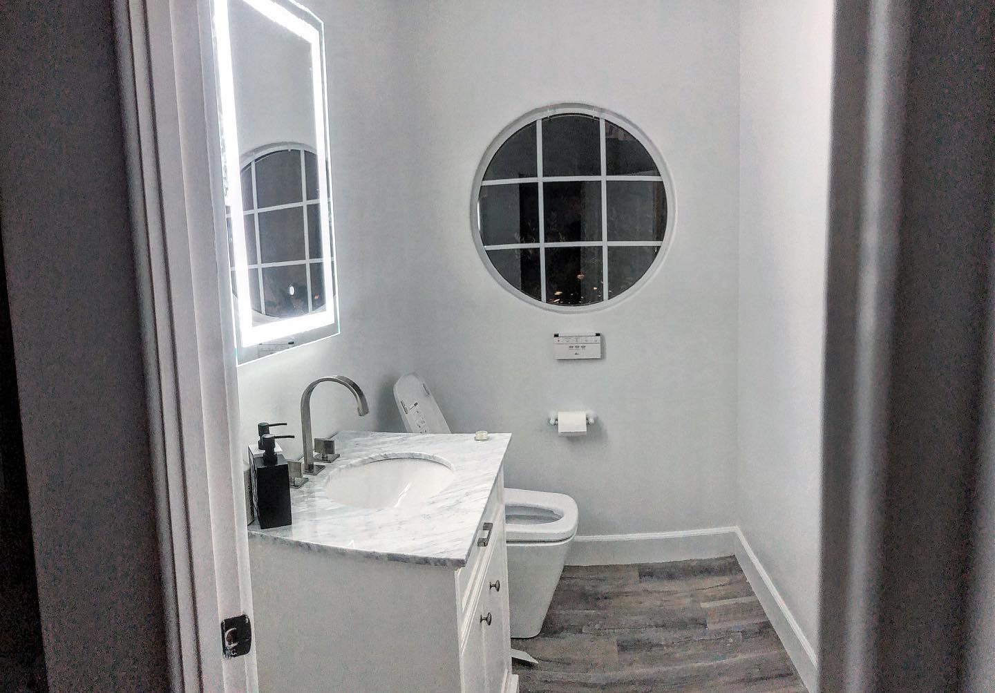 A bathroom with a sink , toilet and mirror.