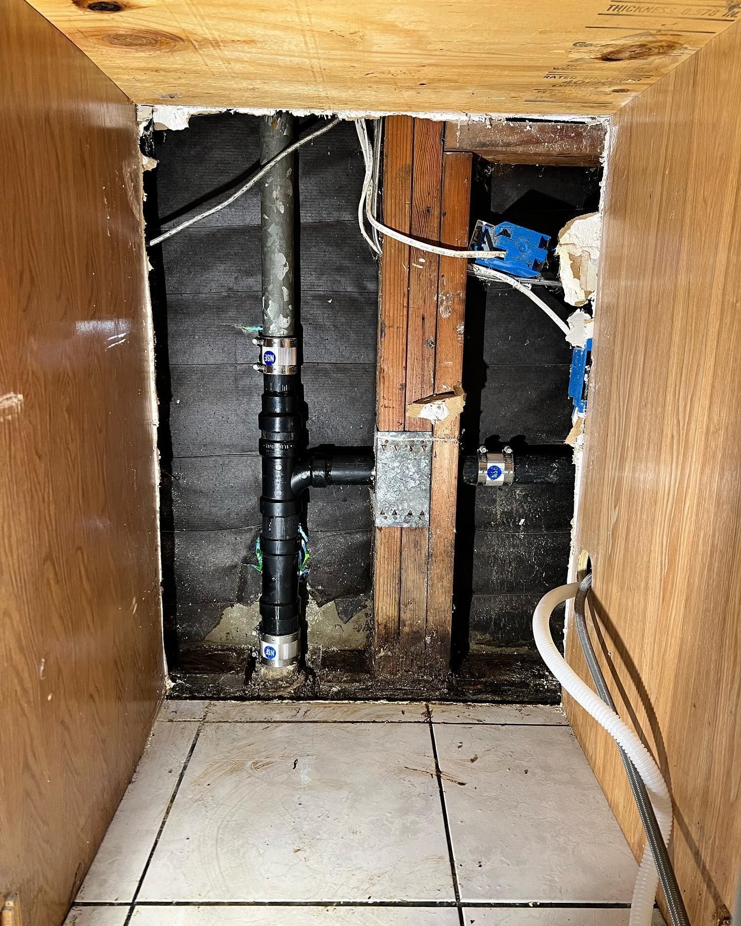 A room with a hole in the wall and pipes coming out of it