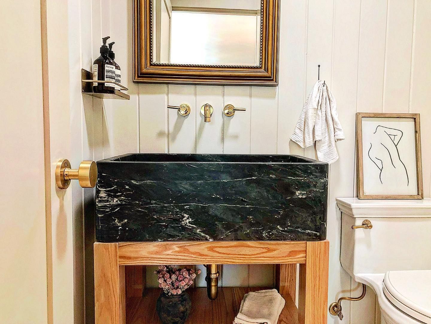 A bathroom with a sink , toilet and mirror.