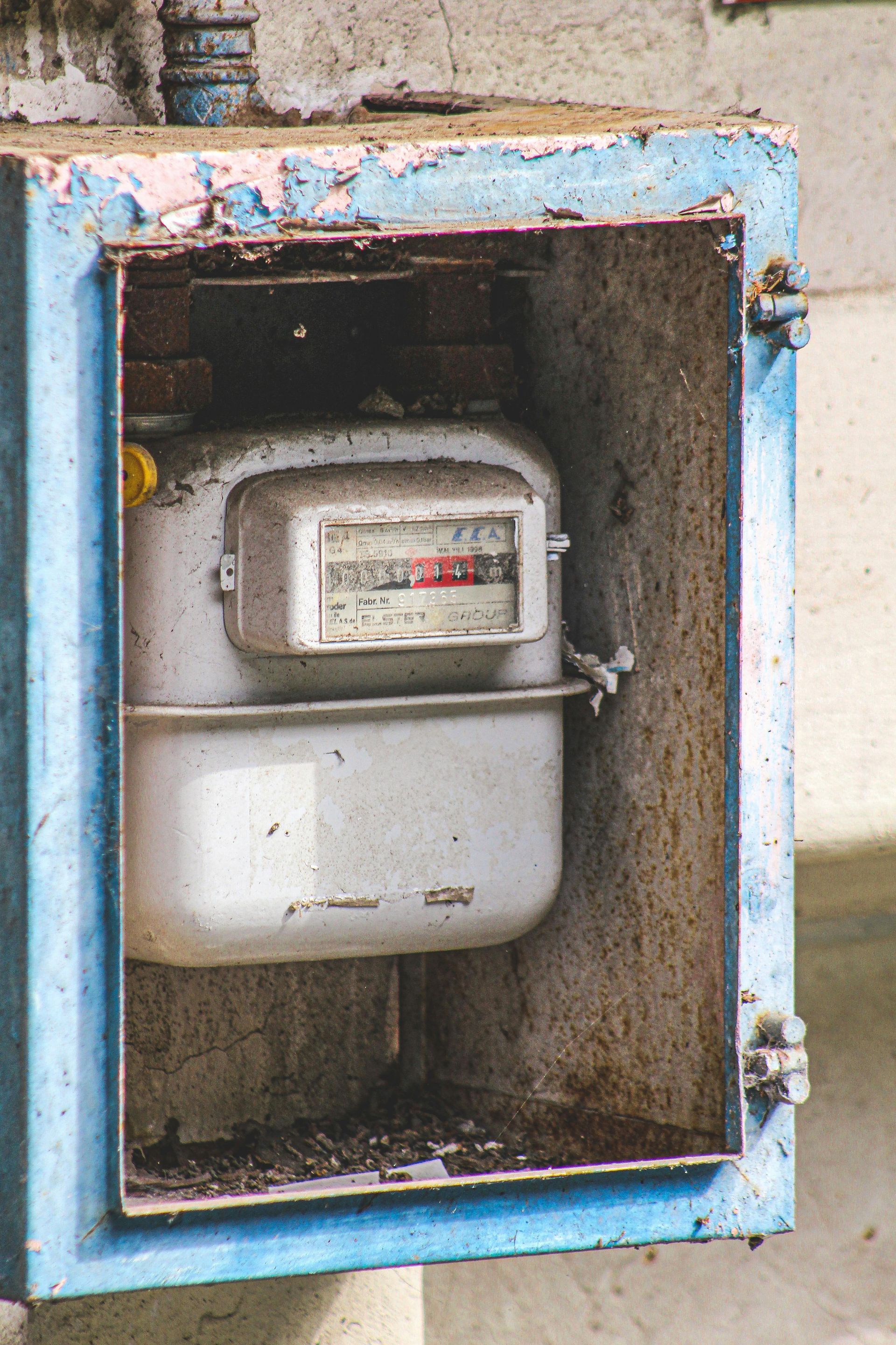 A gas meter is sitting inside of a blue box.