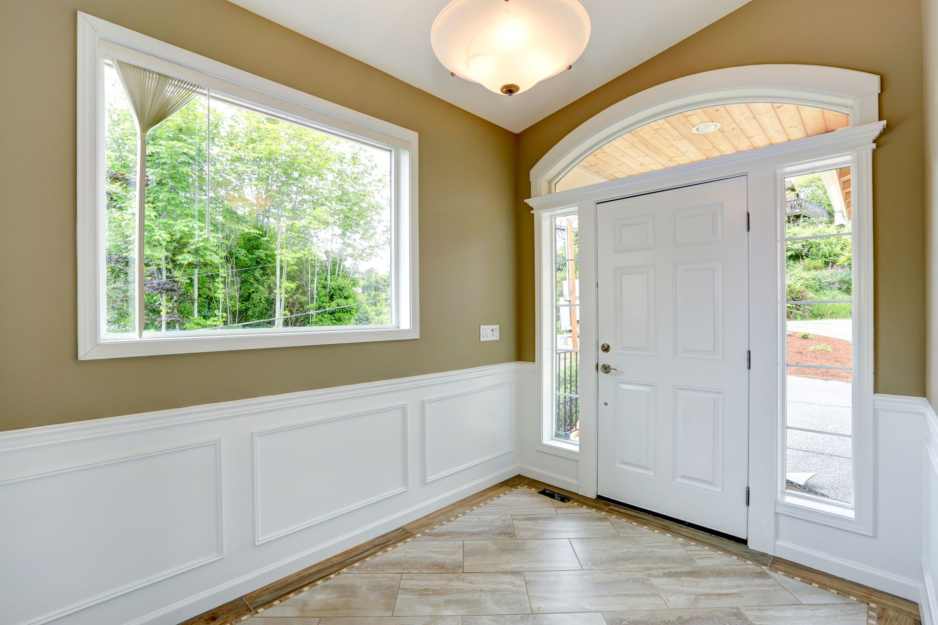 An entryway with an arched window, sidelights, and a rectangular window