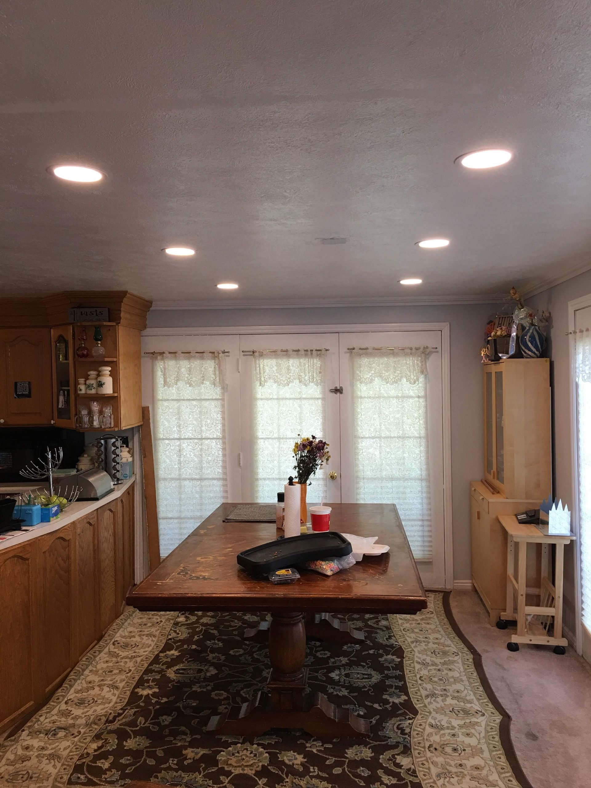 A dining room with a large wooden table and a rug