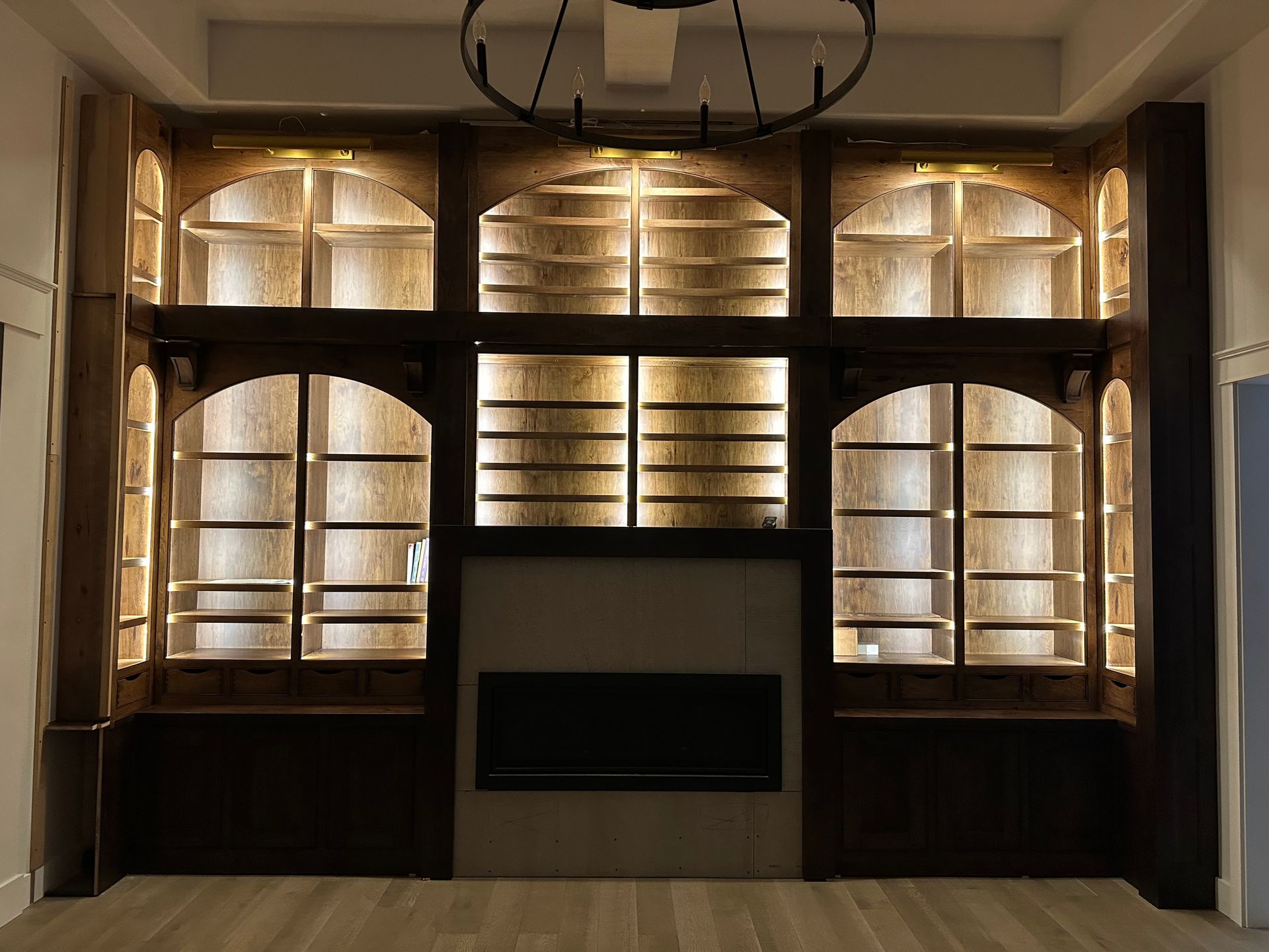 A living room with lots of shelves and a fireplace