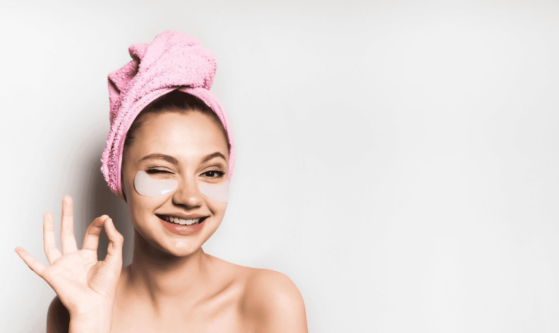 Eine Frau mit einem Handtuch um den Kopf und Augenklappen im Gesicht.