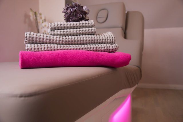 Ein Stapel Handtücher liegt auf einem Stuhl.