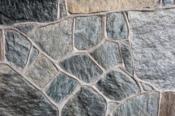 “Close-up of a finished stone masonry wall with varied gray stones and clean mortar lines from a masonry service in Missouri City, TX”