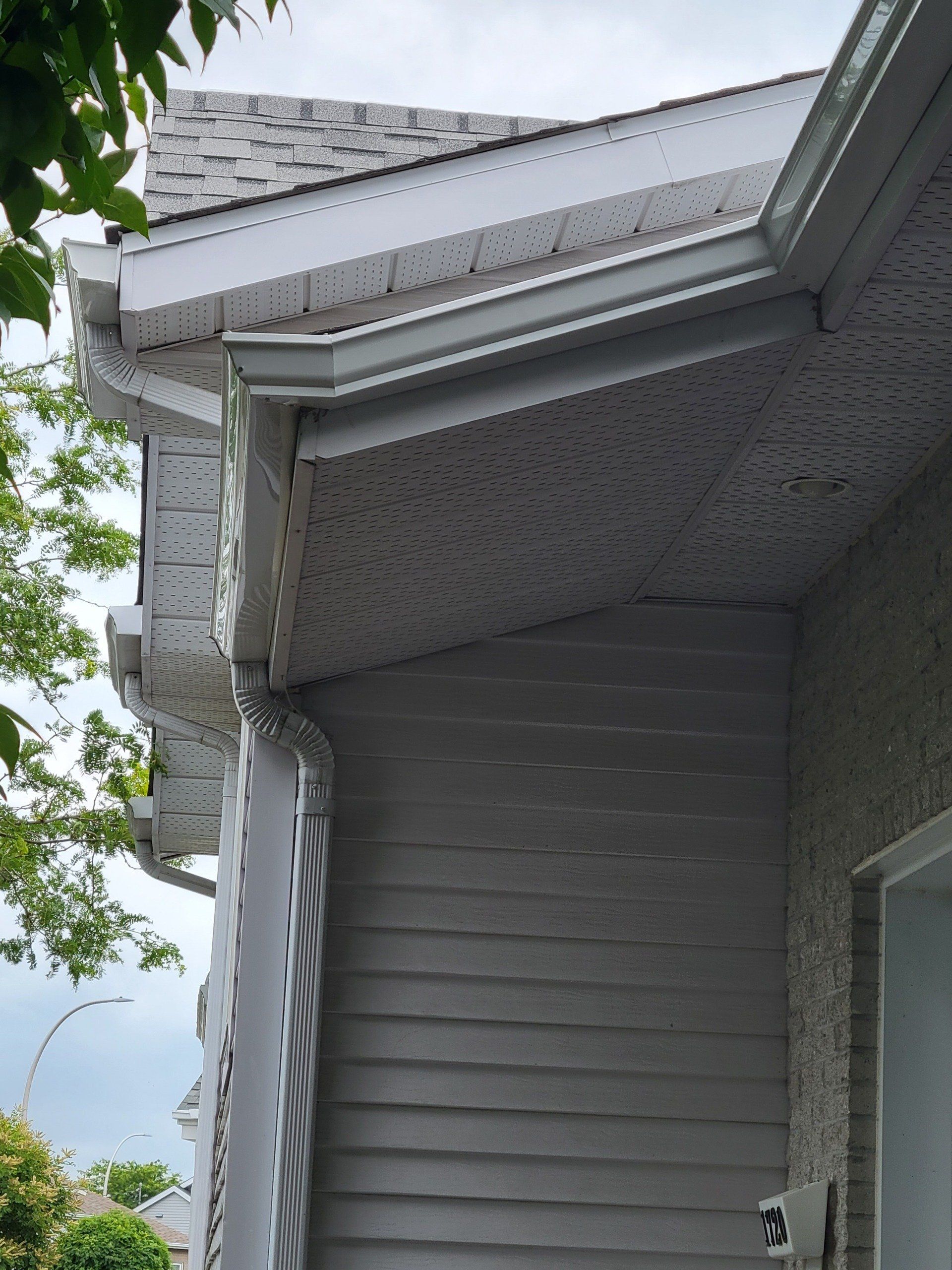 Une maison blanche avec une gouttière sur le côté