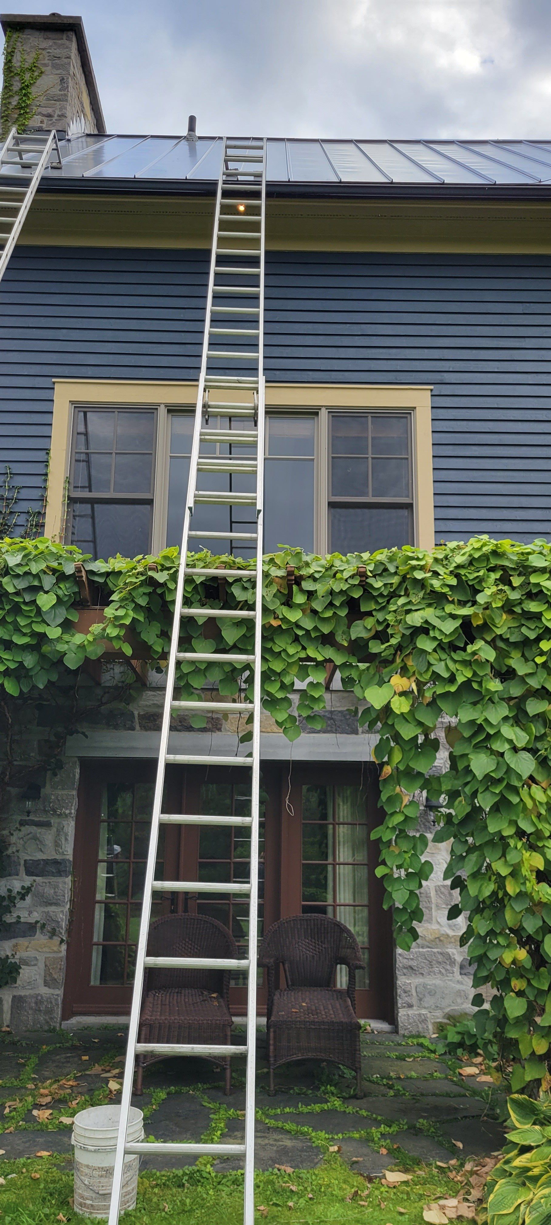 Une échelle est posée sur le côté d'une maison.