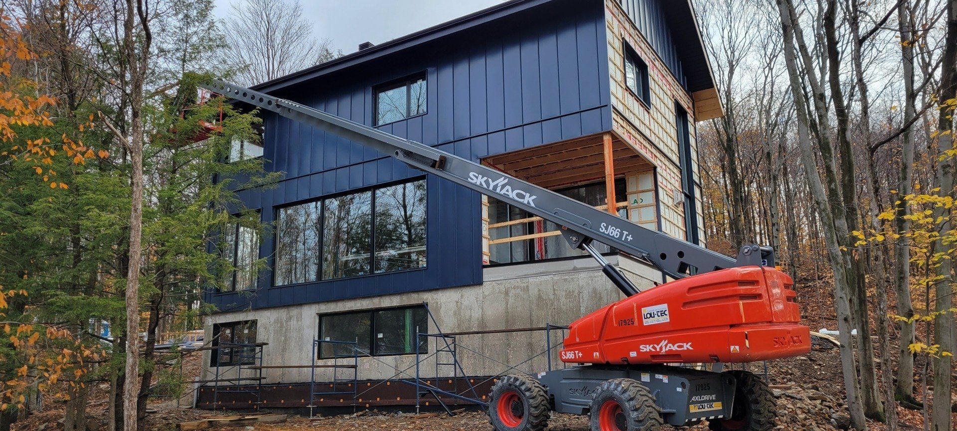Une grande maison est en construction avec une grue devant elle.