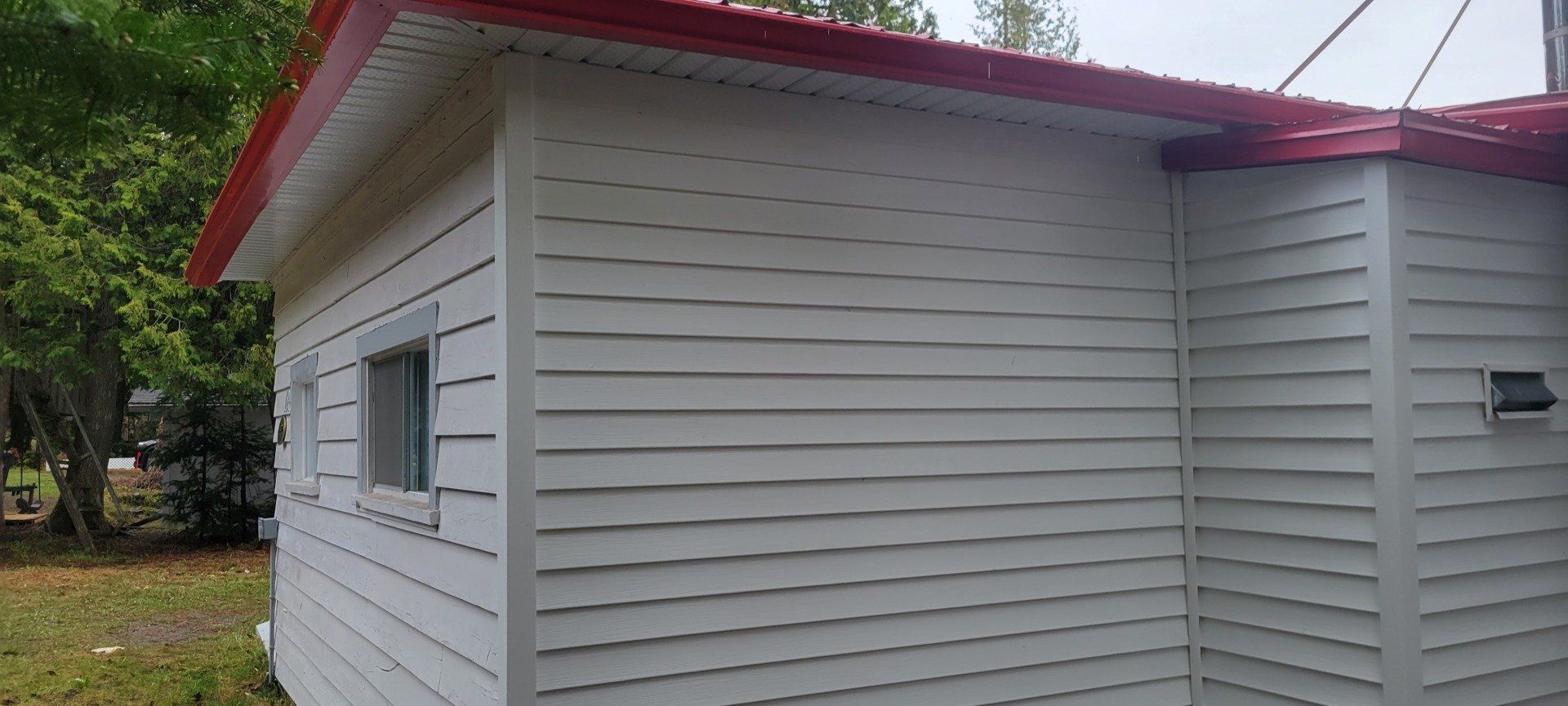 Une maison blanche avec un toit rouge et une fenêtre.