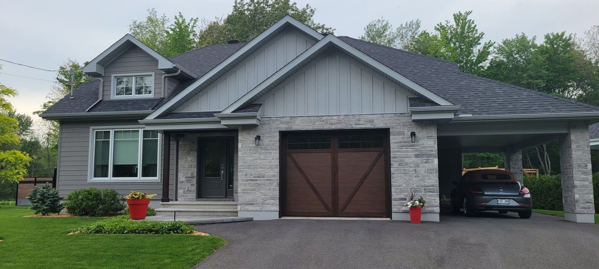 Une maison avec une voiture garée devant et un garage.