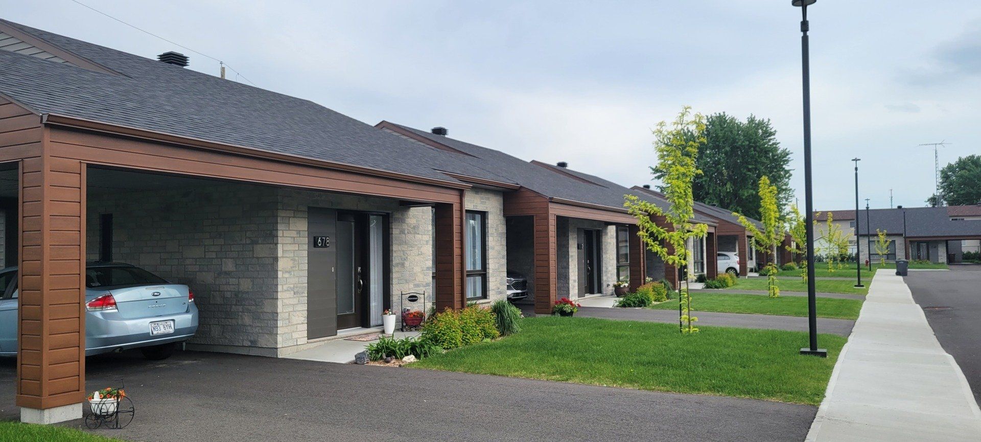 Une voiture est garée sous un porche devant une rangée de maisons.