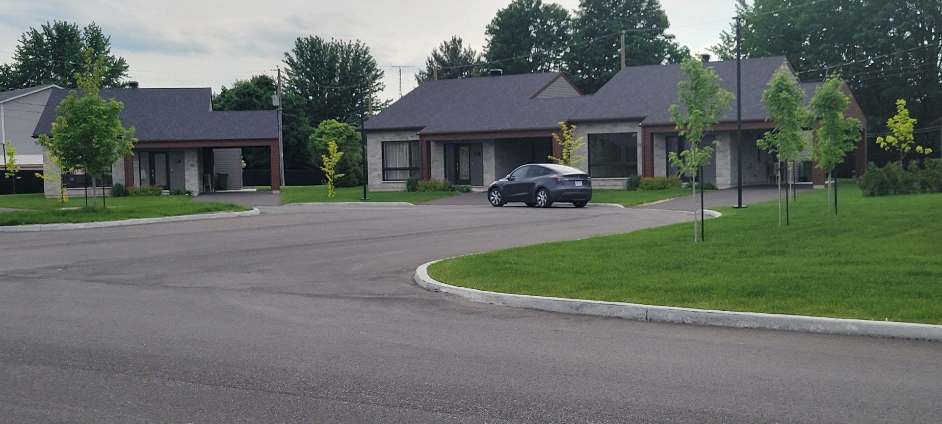 Une voiture est garée sur un parking devant une maison