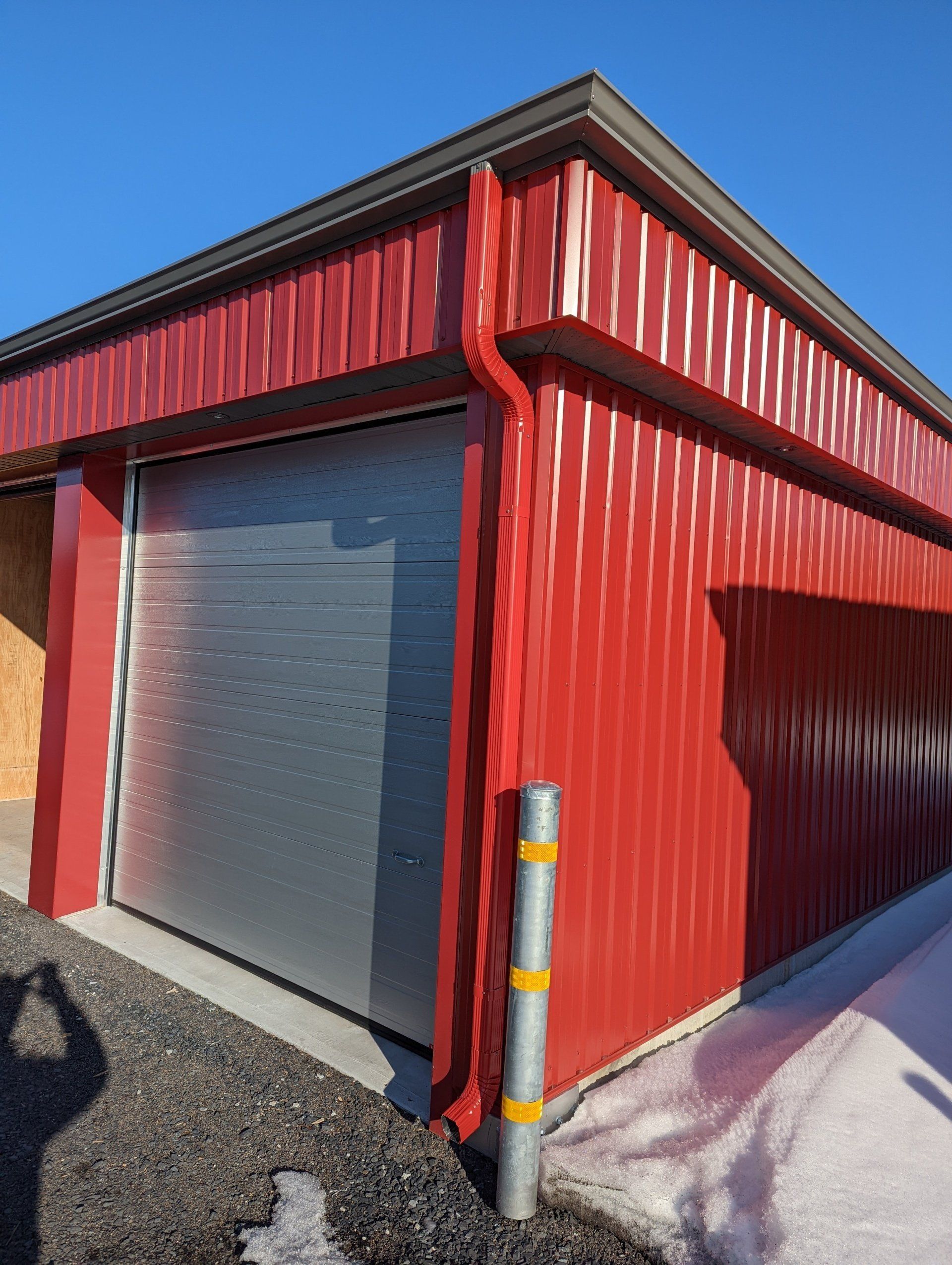 Un bâtiment rouge avec une porte de garage et un tuyau d'évacuation