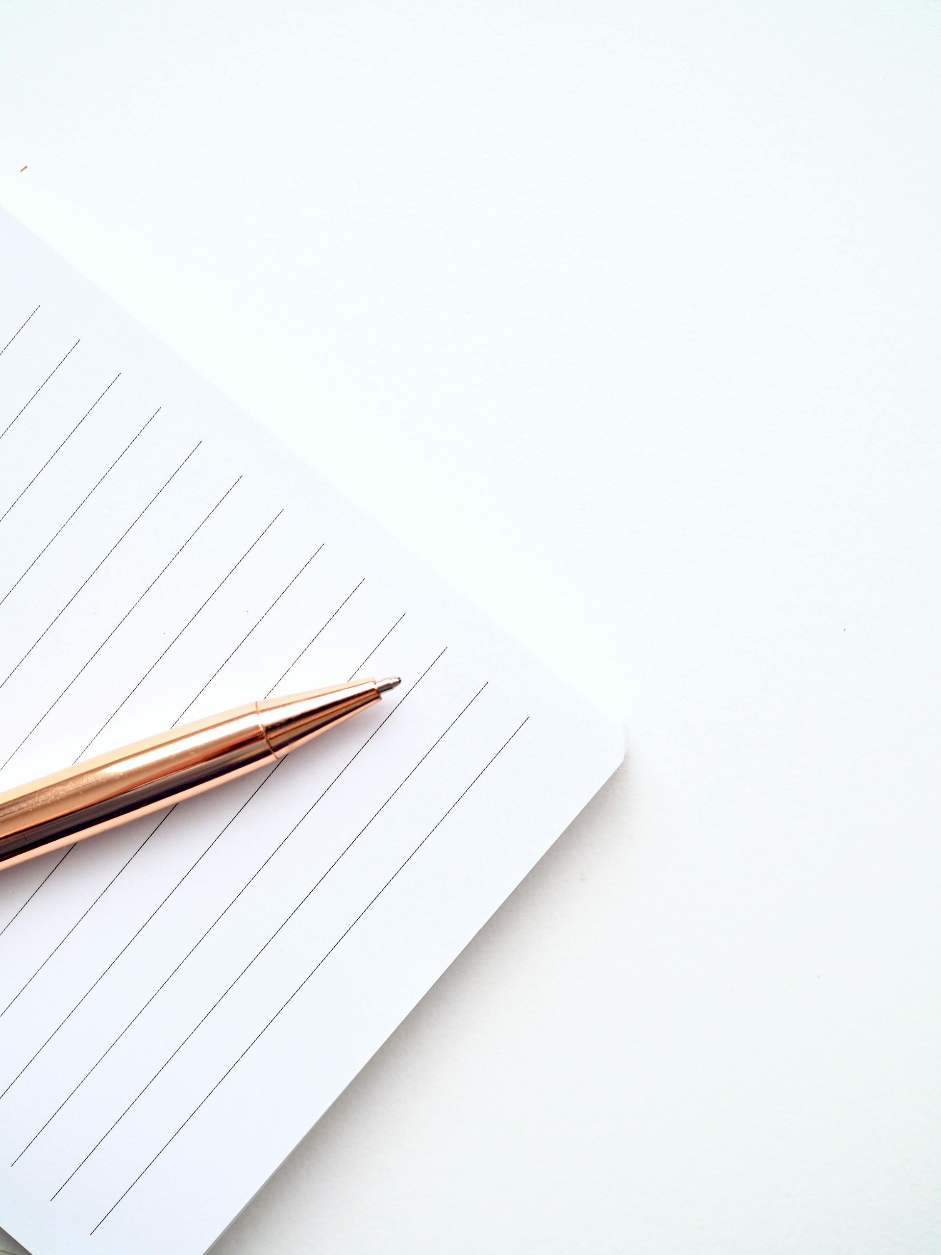 A woman is writing on a piece of paper with a pen.