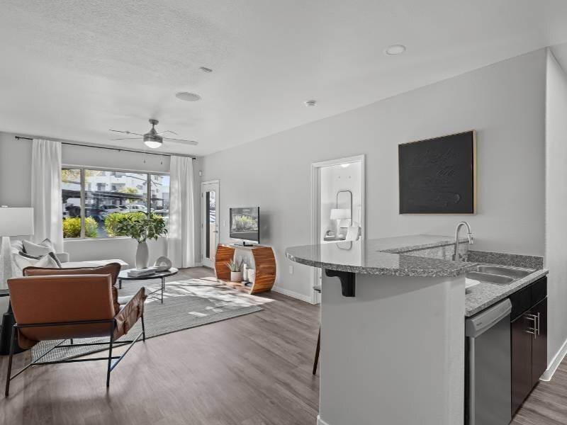 Open-concept living area with seating, large window, and granite kitchen island.