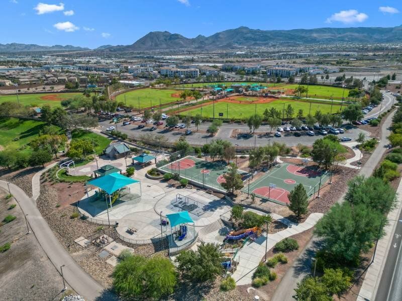 Aerial view of a multifamily community with playgrounds, basketball courts, and green spaces.