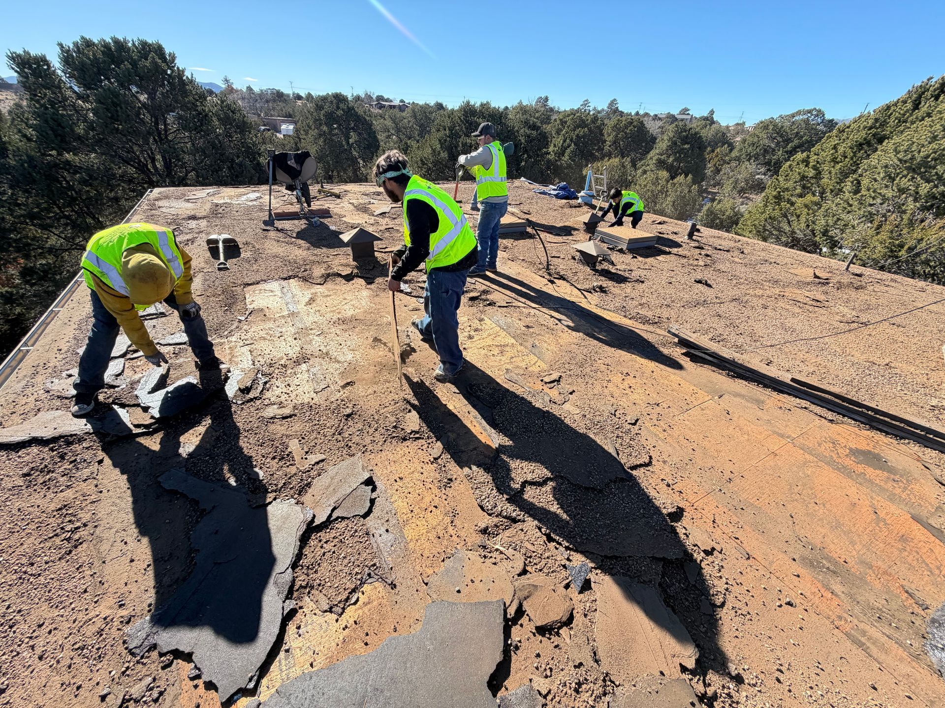 Roof partially covered with blue underlayment; a house is under construction.