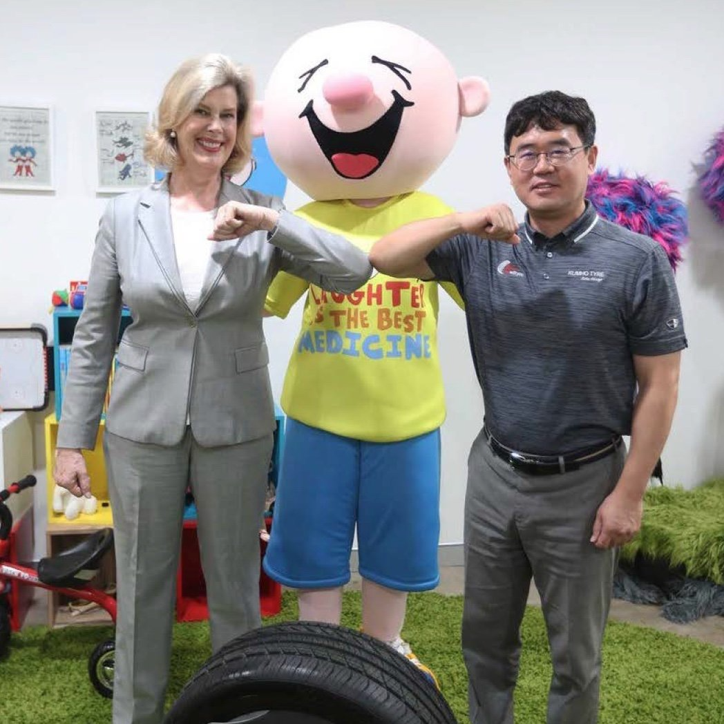 Kumho Tyres employees posing with the Camp Quality mascot