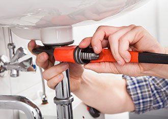Drain Cleaning — Plumber Fixing Bathroom Sink in Denton, TX