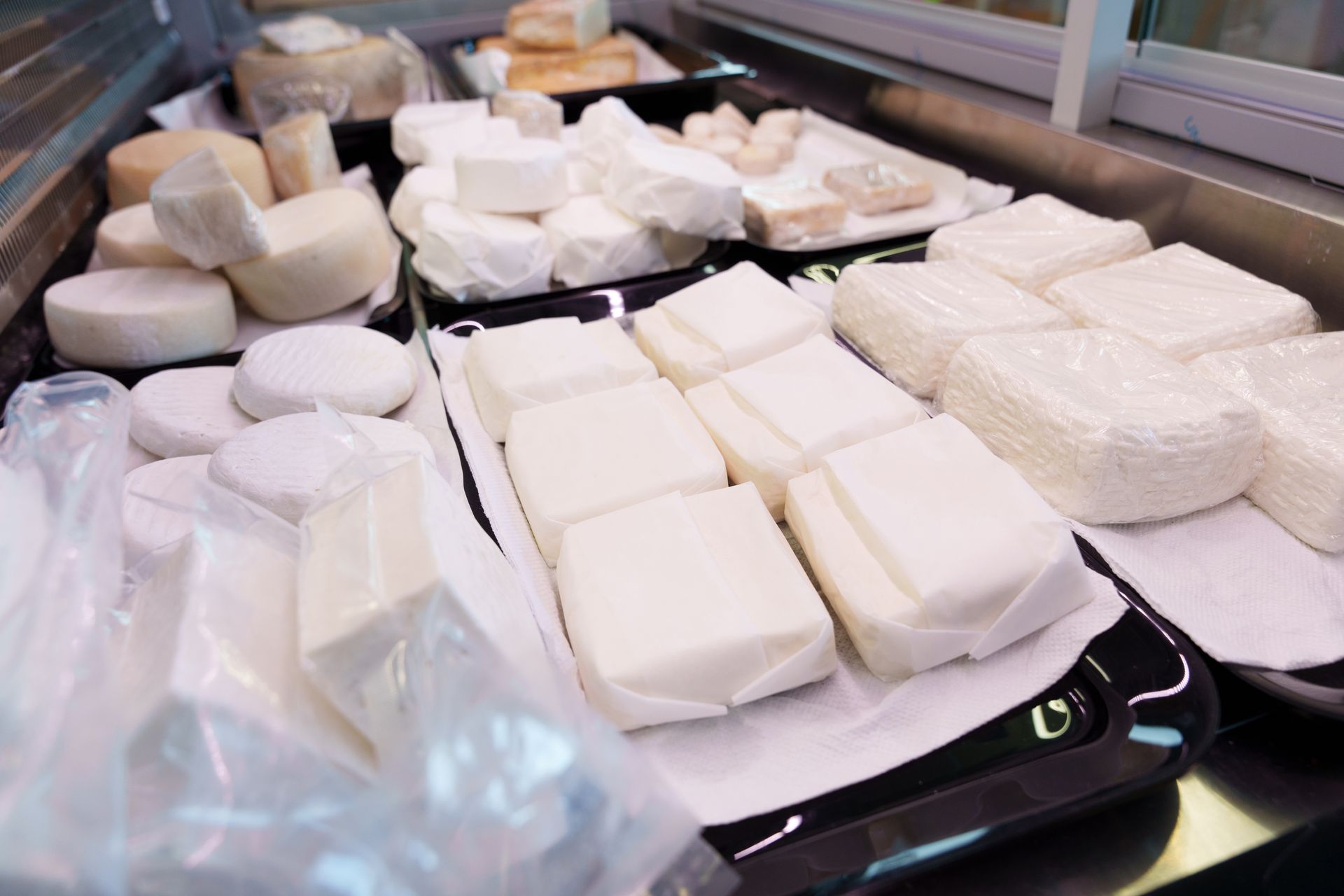 Una vetrina piena di tanti tipi diversi di formaggio di capra