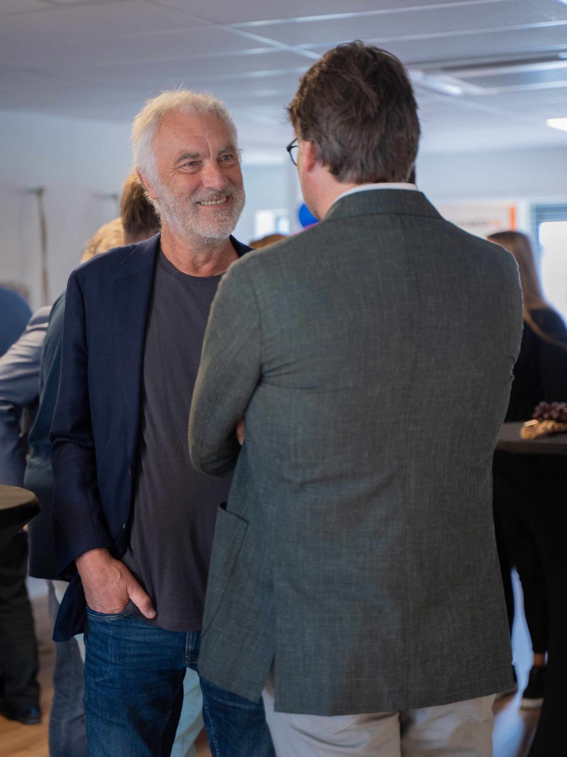 Een man in een pak praat met een andere man