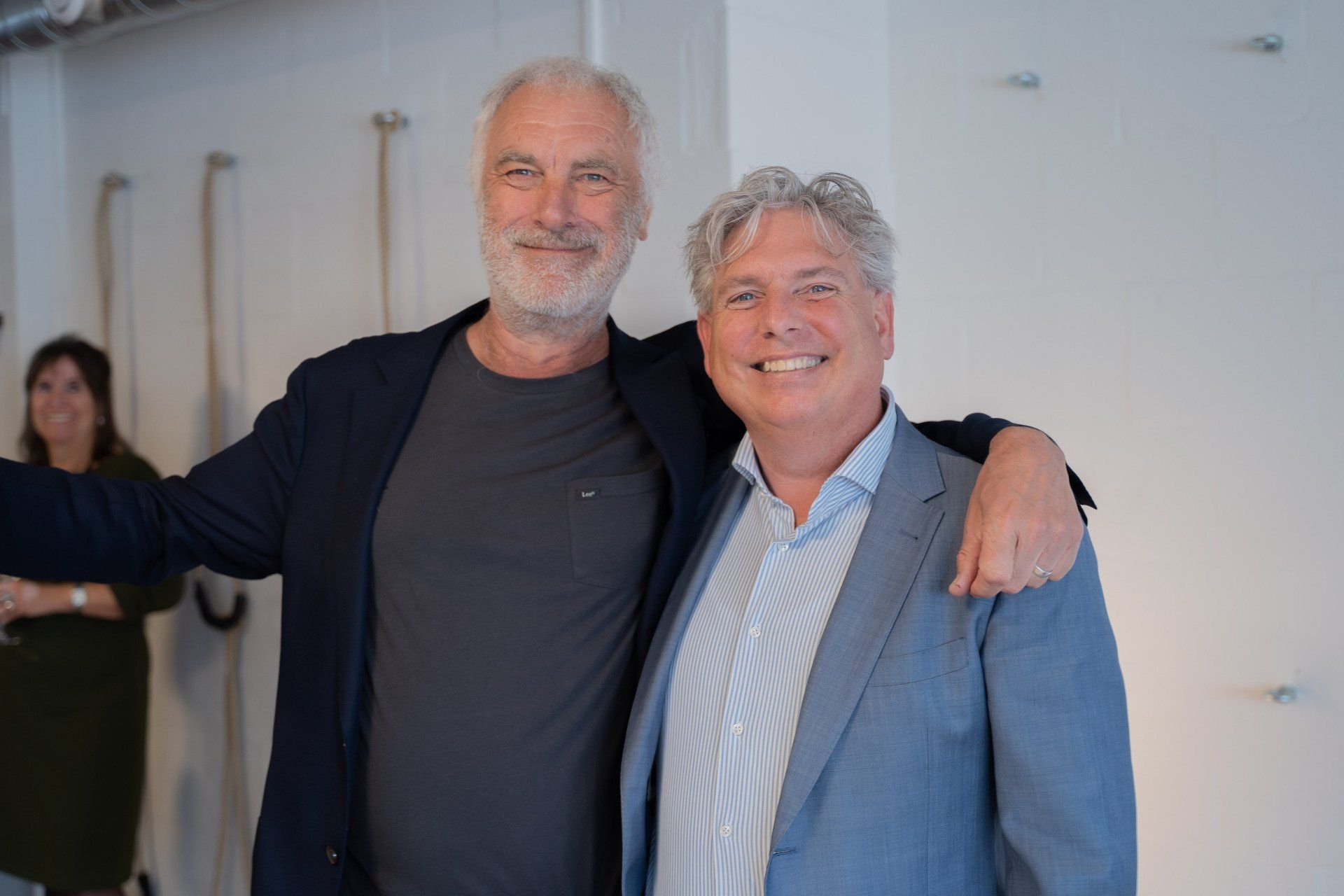 Twee mannen poseren samen voor een foto in een kamer.