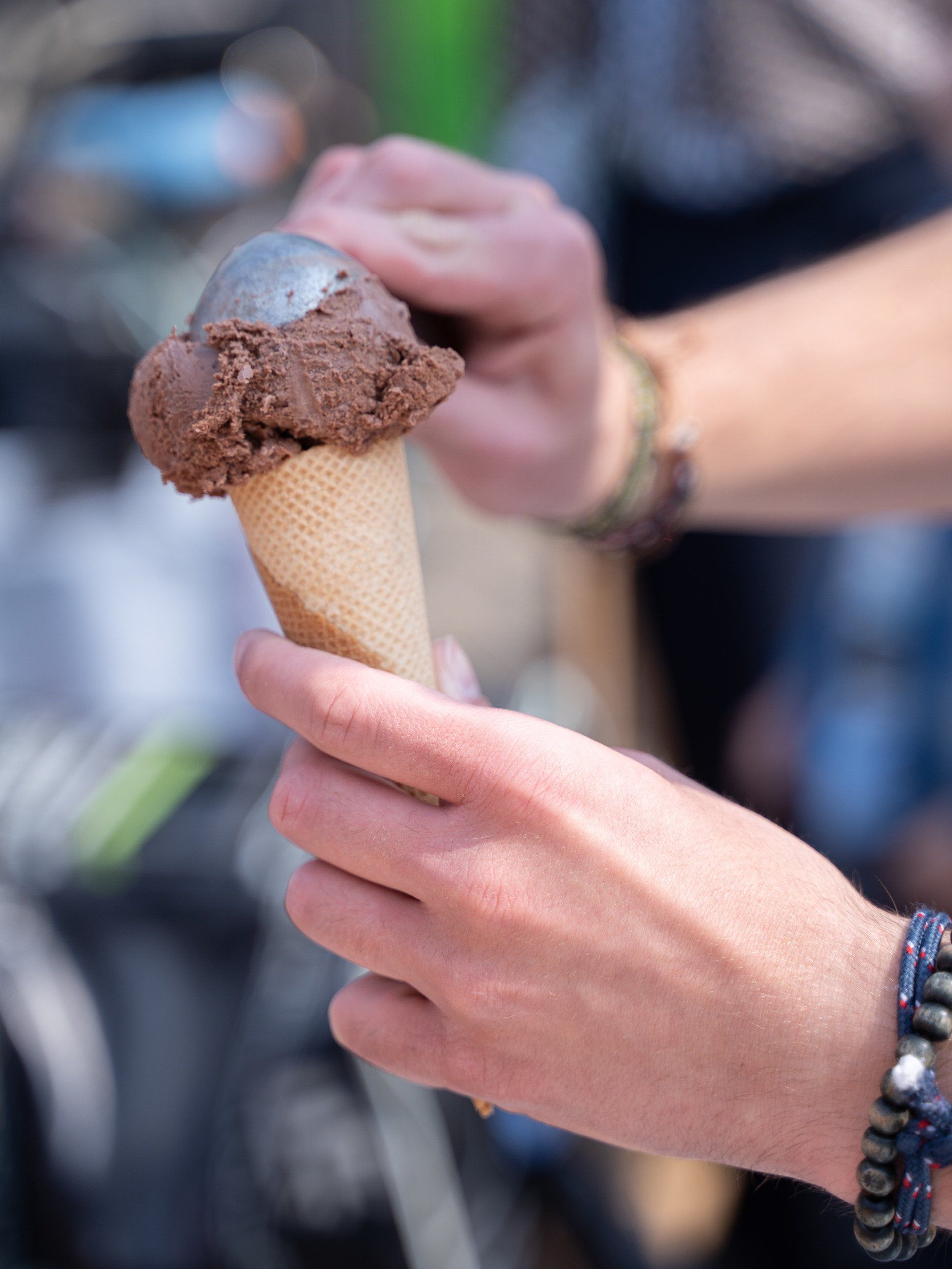 Een persoon houdt een chocolade-ijshoorntje in zijn hand
