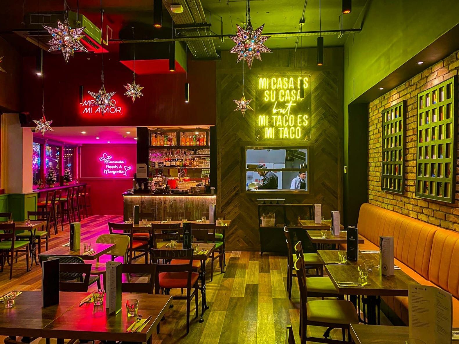 A restaurant with tables and chairs and a neon sign that says nights at su casi