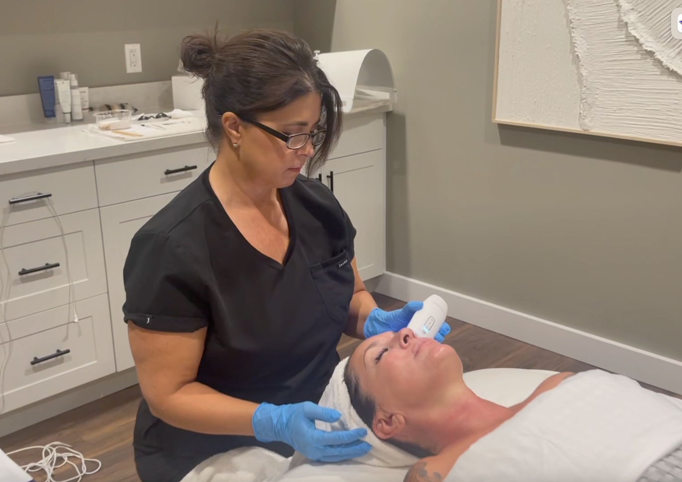 A woman is giving a woman a facial treatment in a salon.