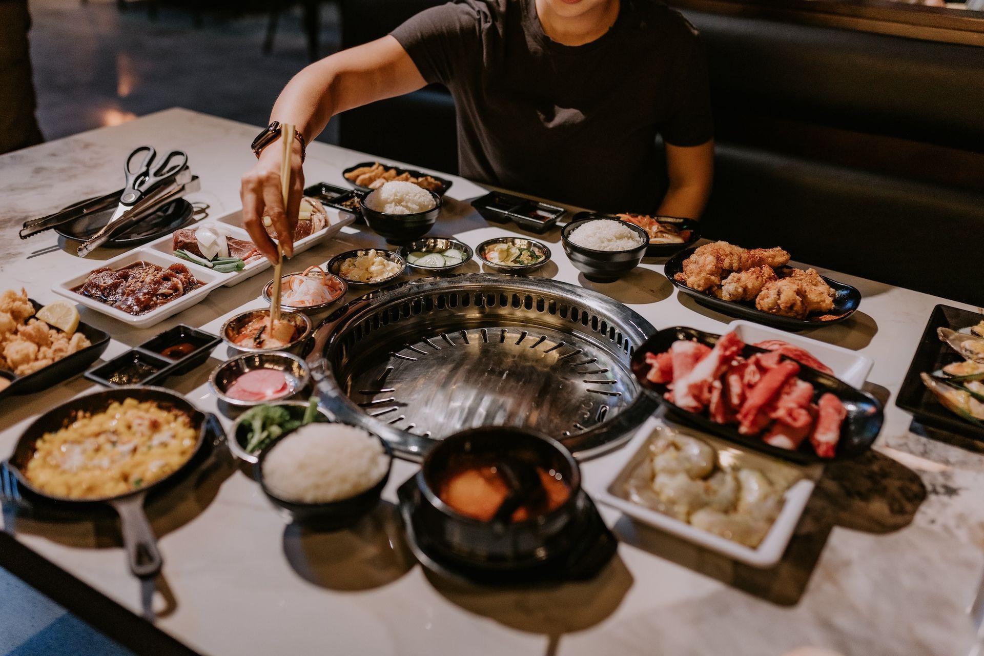 A man is sitting at a table with plates of food.