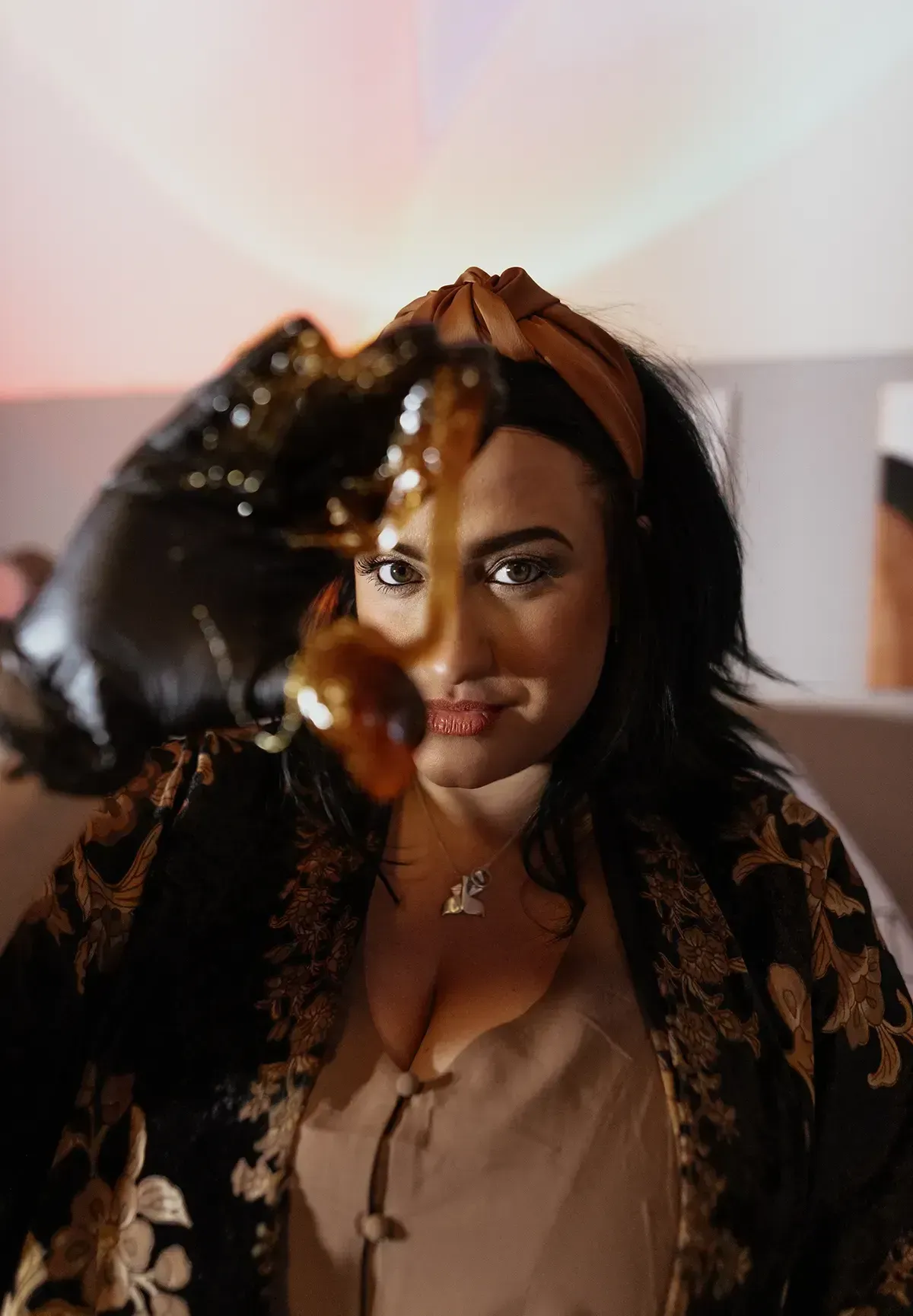 A woman is holding a cup of coffee in front of her face.