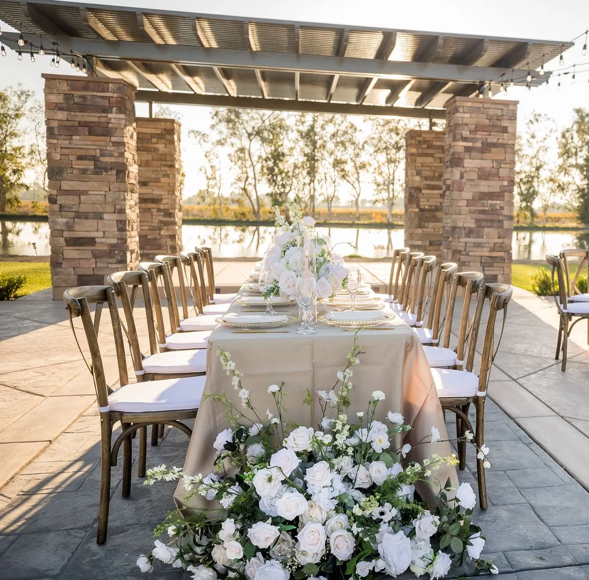 A long table with chairs and flowers on it