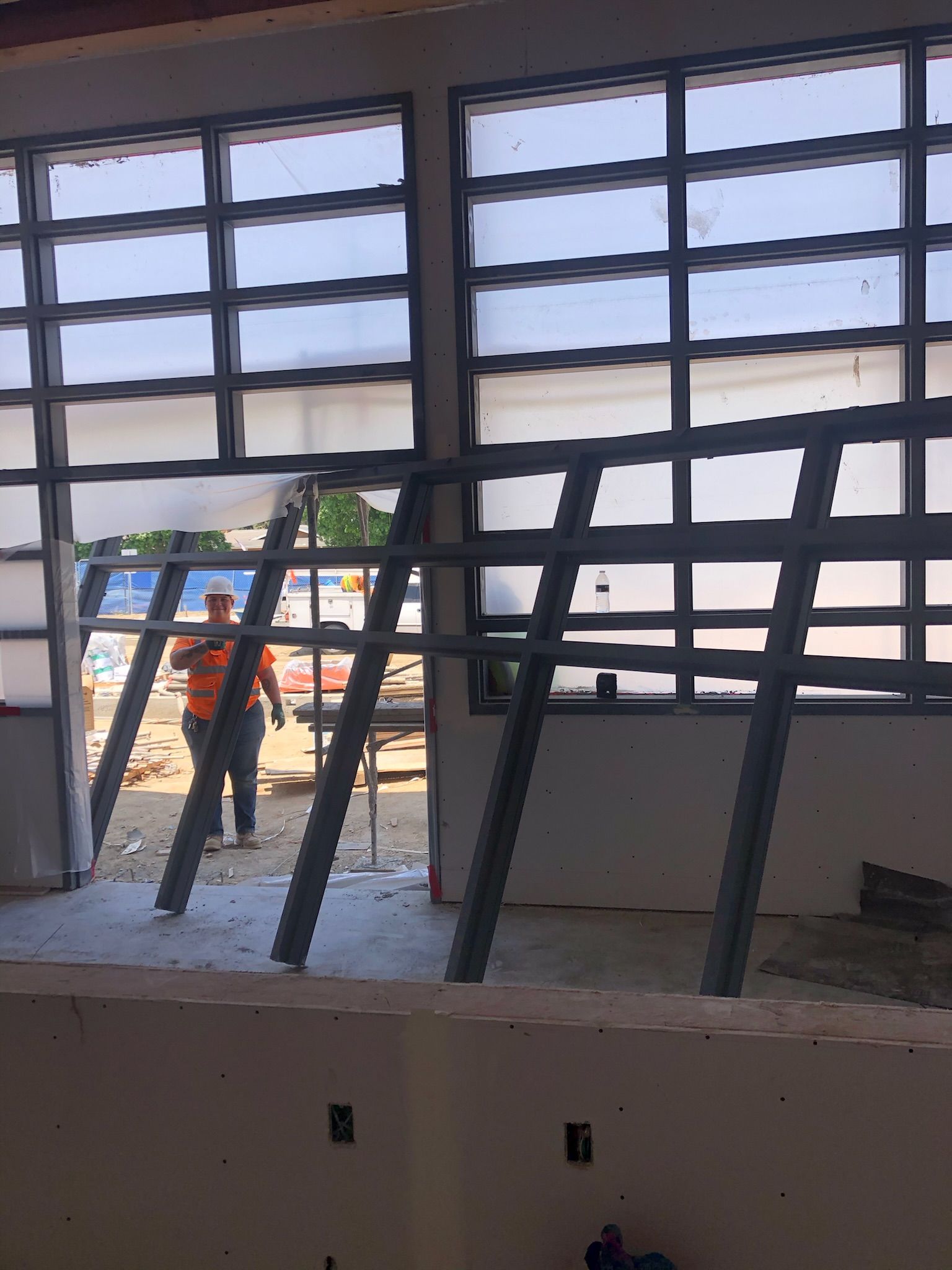 Construction worker near a window frame with grid pattern.