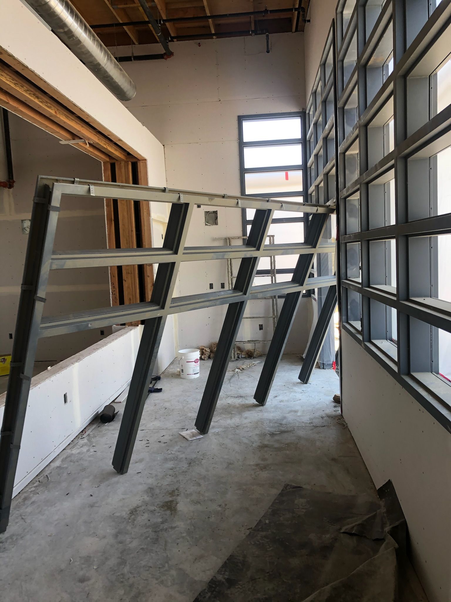 Interior construction with metal framing for windows and a wall in a building.
