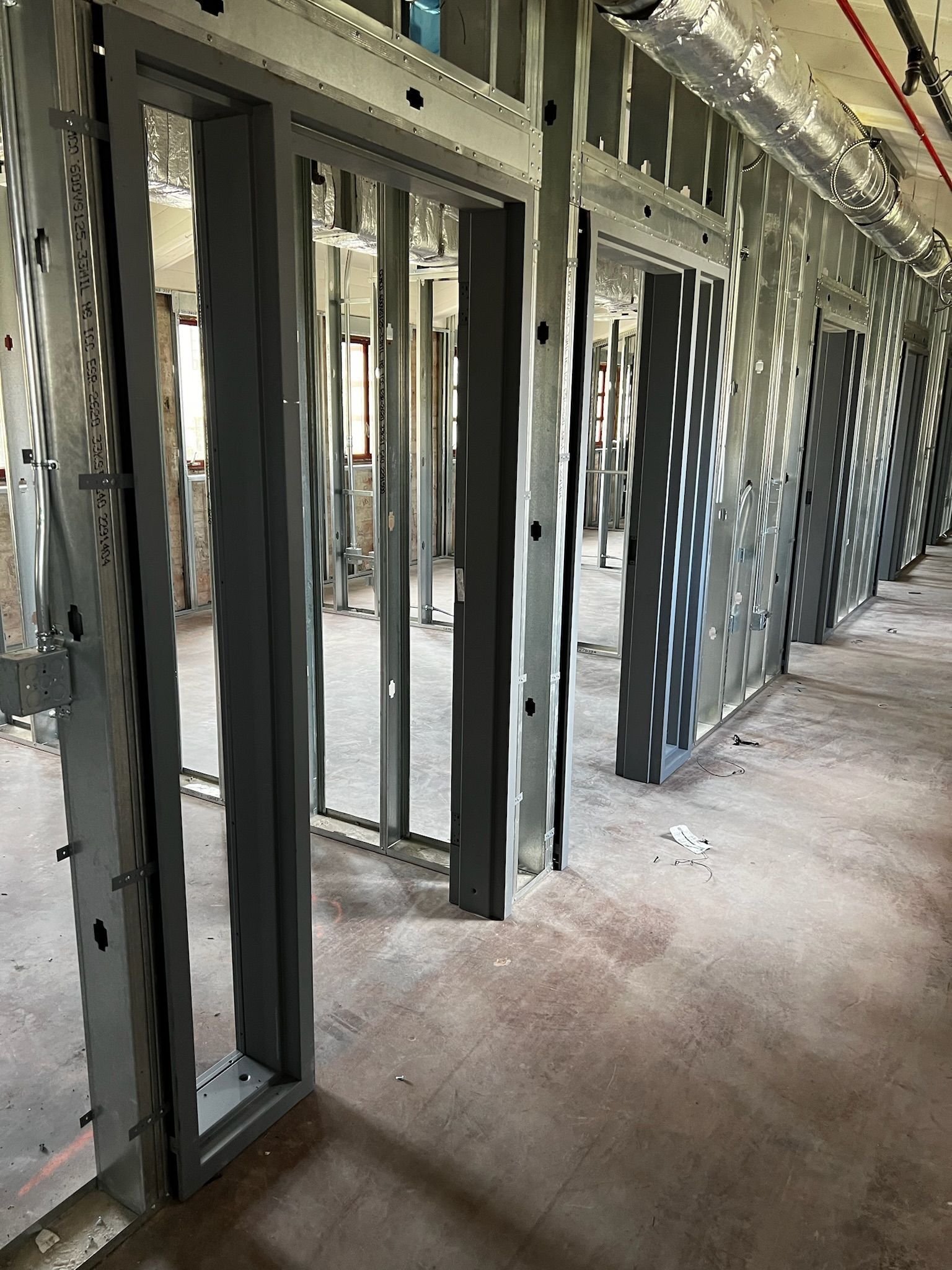 Interior construction site with metal door frames and unfinished walls.