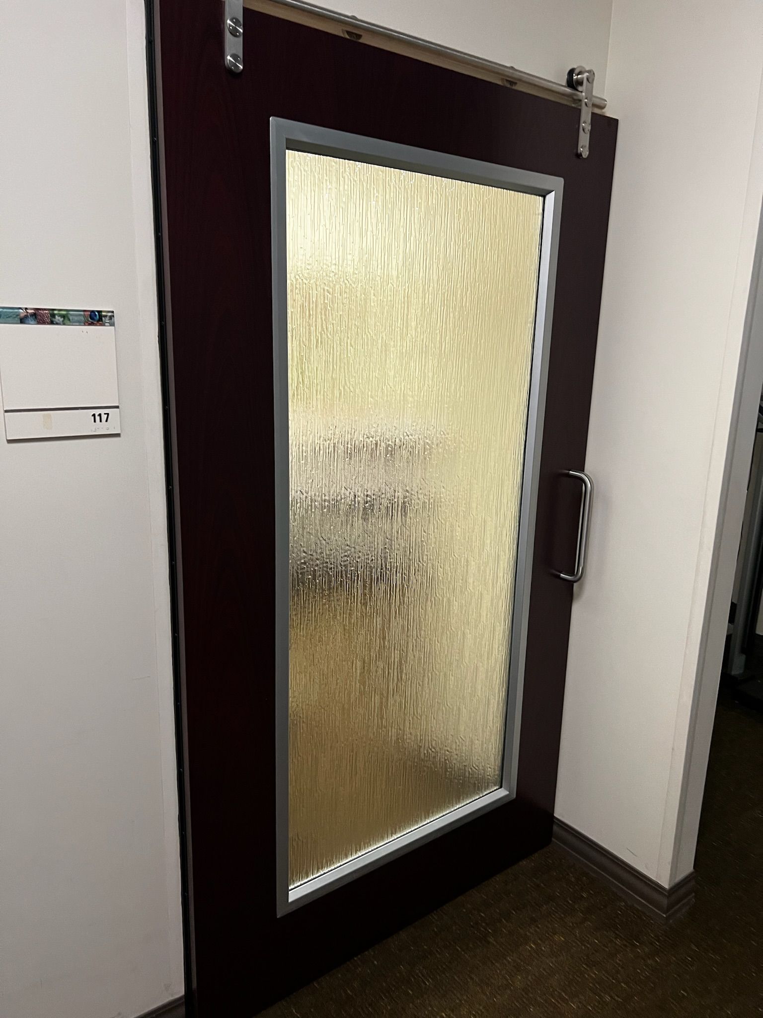 Dark burgundy sliding door with textured glass panel, silver hardware, and a modern handle.