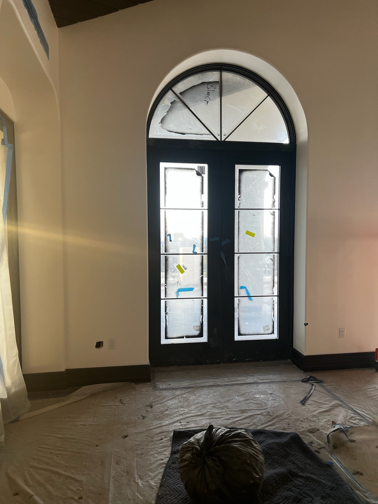 Black arched double doors with glass panels; interior view.
