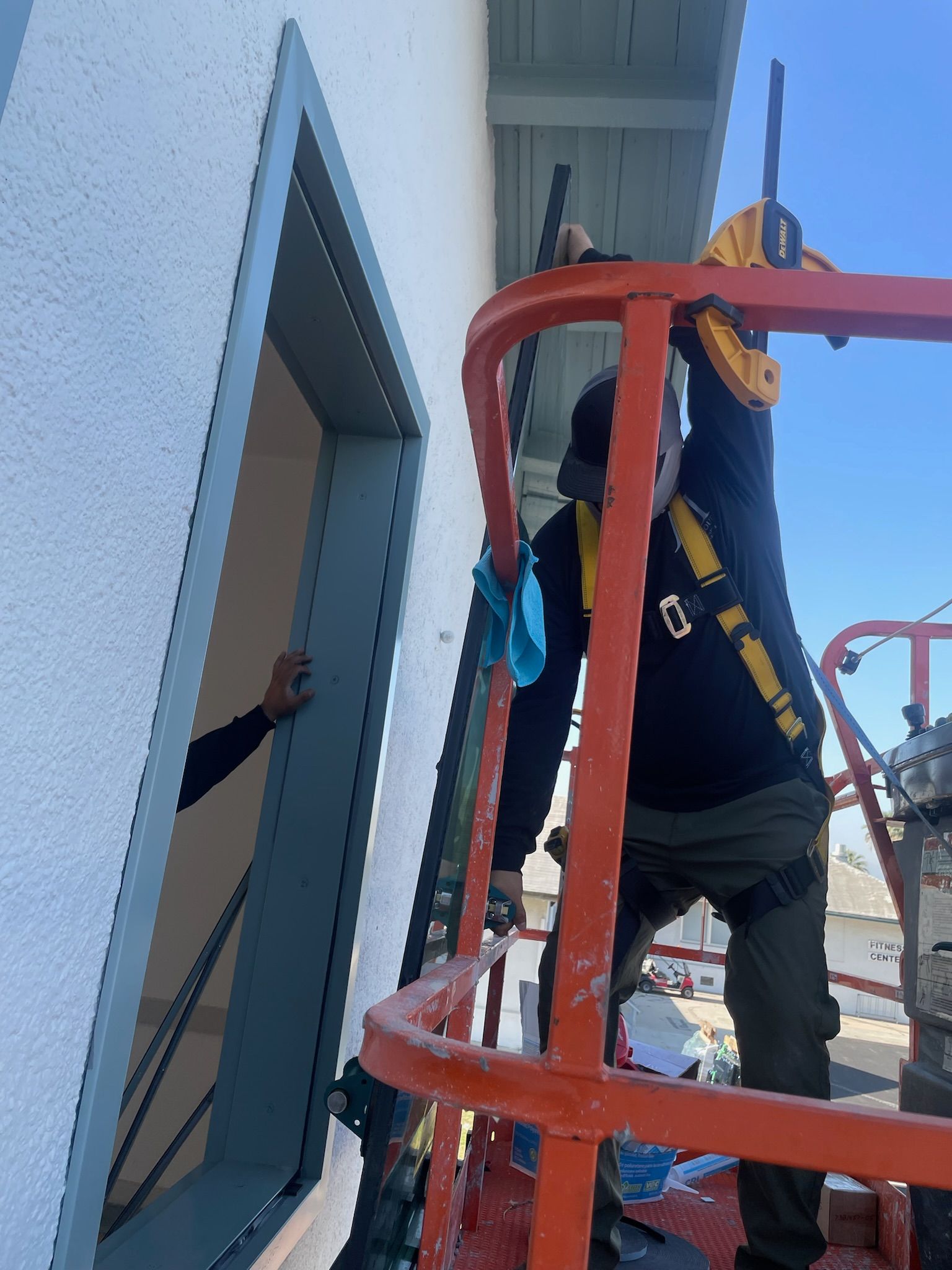 Two window cleaners on a lift, cleaning exterior window.