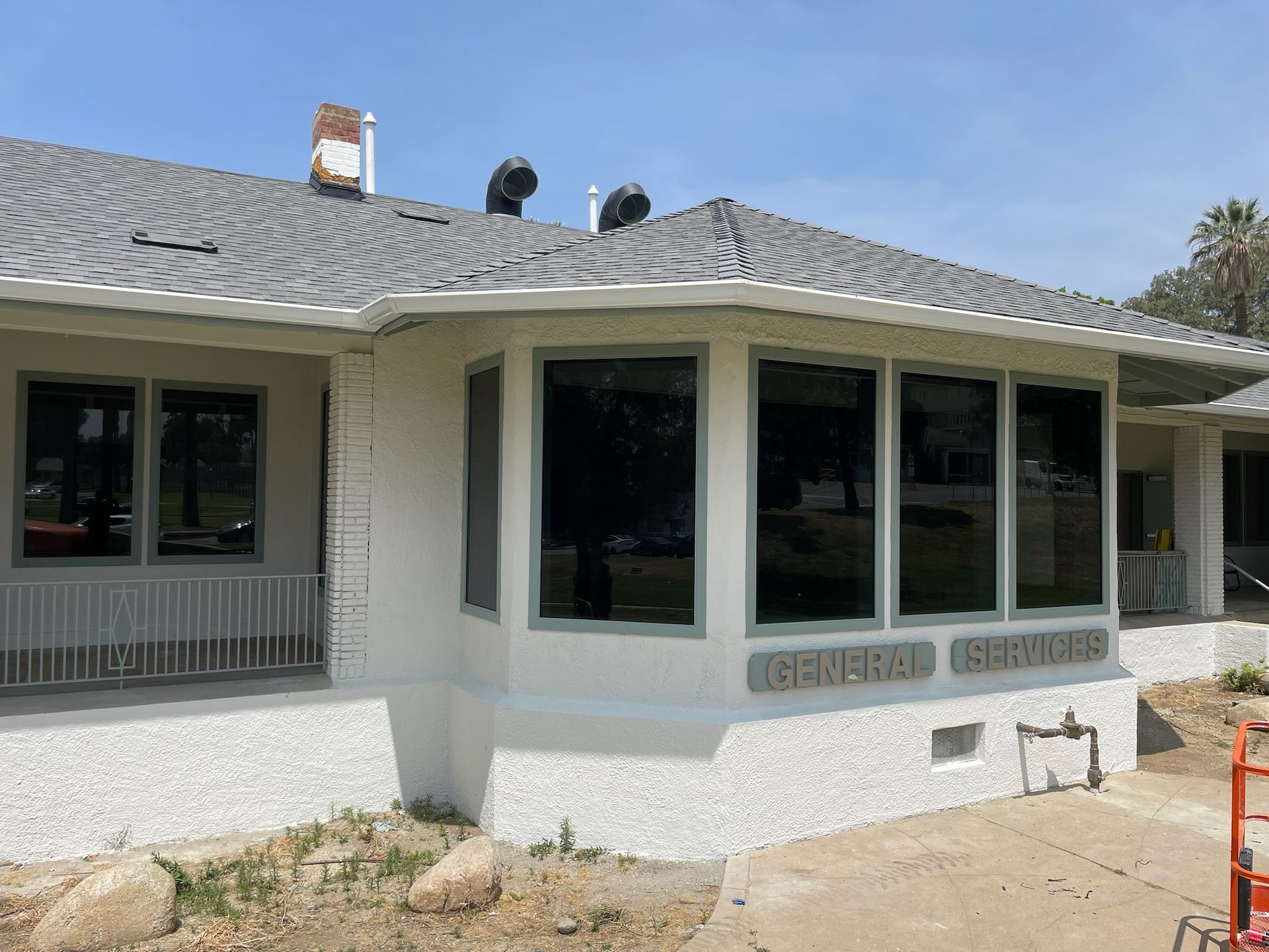 Exterior view of a white building with dark-tinted windows and the words 