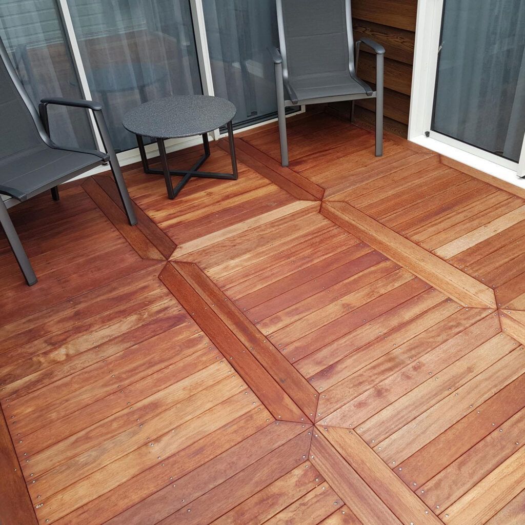 A wooden deck with chairs and a table on it.