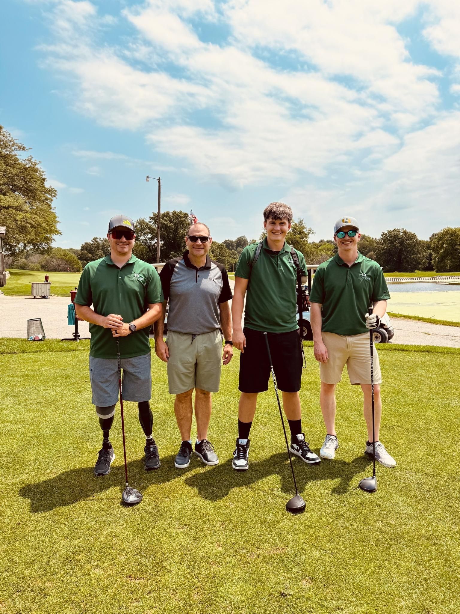 A group of men standing next to each other on a golf course holding golf clubs.