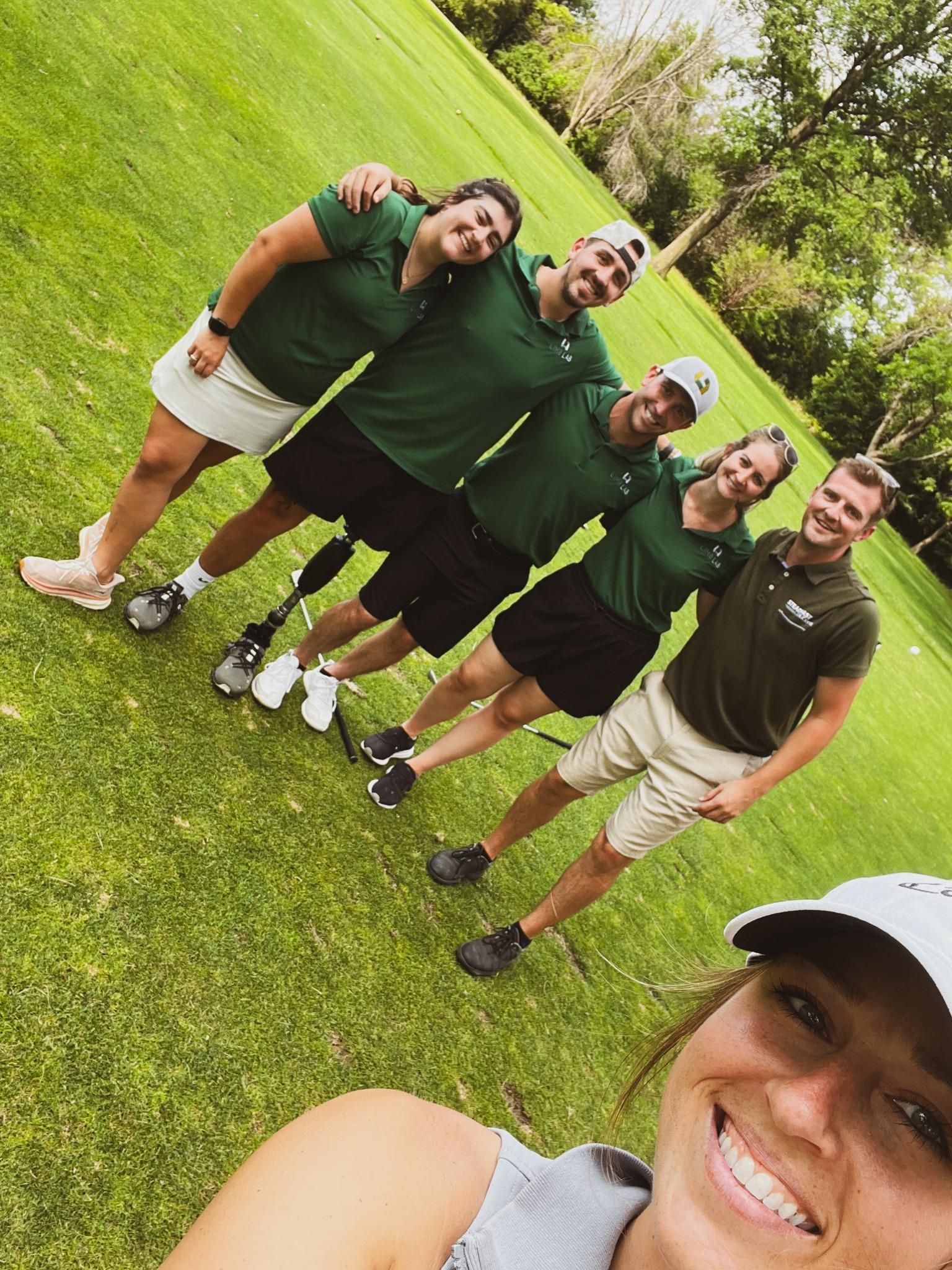 A group of people are posing for a picture on a golf course.