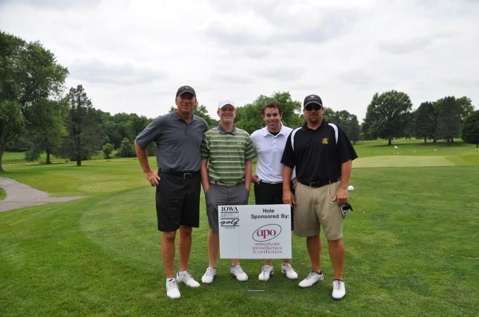 A group of men are posing for a picture on a golf course.