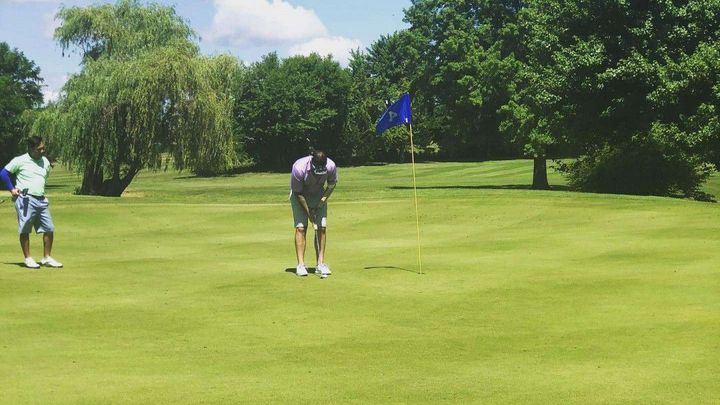 Two people are playing golf on a golf course.